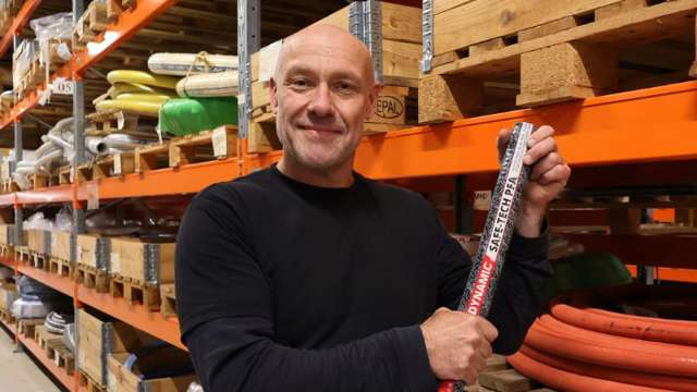 Lagerarbetare håller i en industrislang